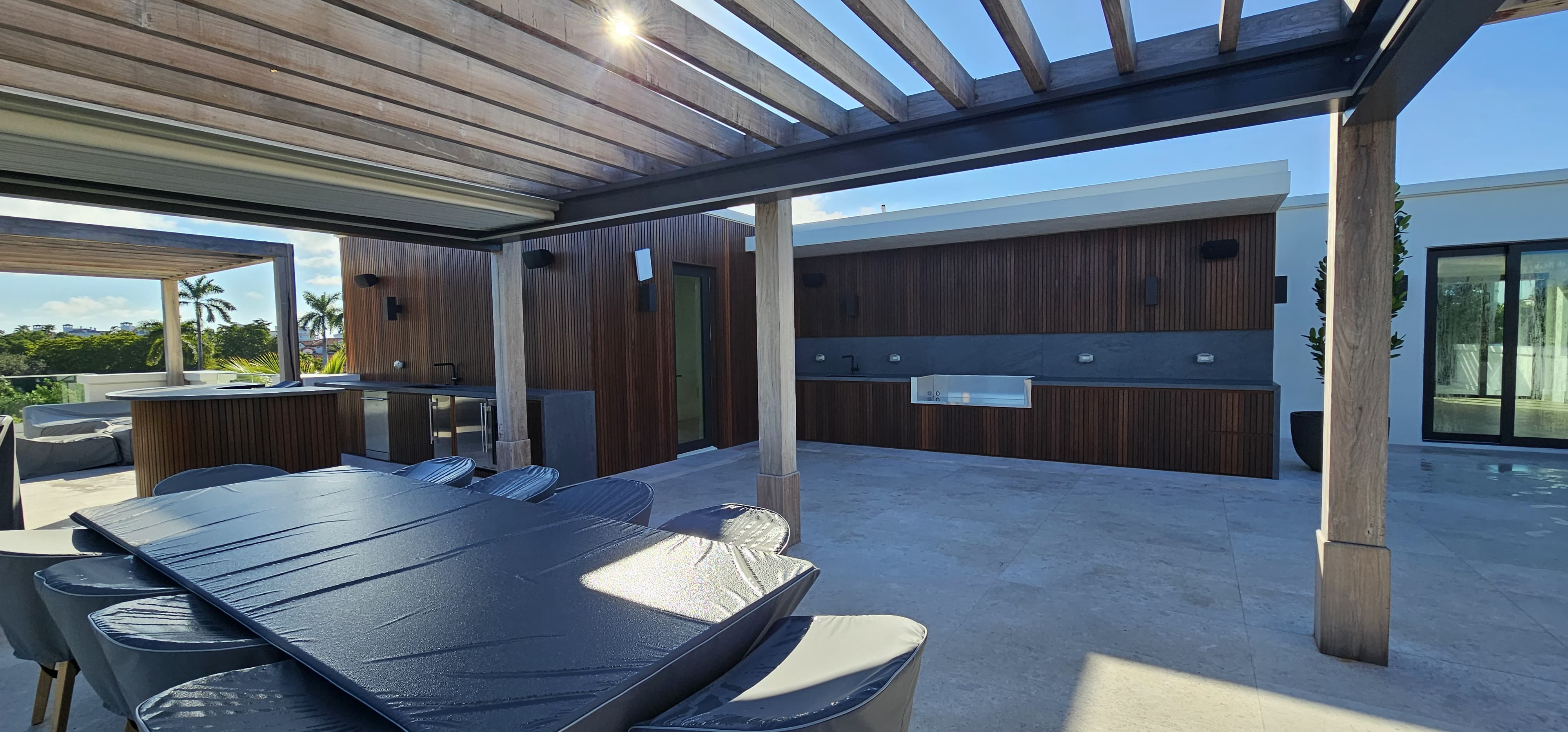 Modern pergola with outdoor kitchen and wood slat cladding